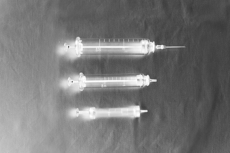 three old medical glass syringes. computer processing, inversion, black and whiteの写真素材