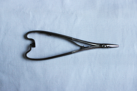 Medical instrument one needle holder lies on a blue clothの写真素材