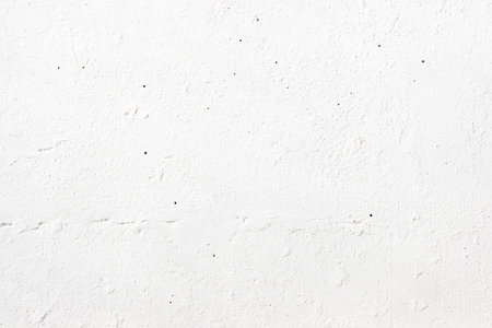 The texture of an old white wall painted with paint, on a bright spring sunny day.の写真素材