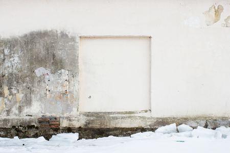 old beige wall with a square groove in the wall in place of the window with peeling plaster for background. sealed window. And snowの写真素材