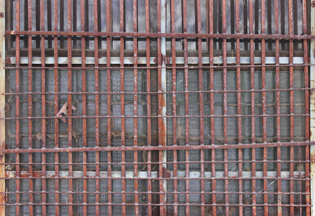 thick rusty old grate on the window of the house. frequent rods.の写真素材