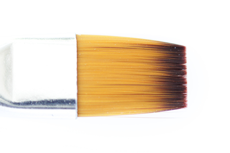 One Watercolor Acrylic art Golden Synthetic flat synthetic brush macro on a white backgroundの写真素材