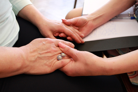 Two girls hold each other's hands during a training course. two girls hold hands on a course on teaching esoteric techniques. friendly support and mutual study of beliefs.の写真素材