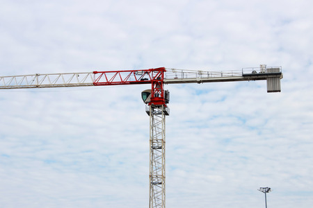 Crane on the background of the sky and white clouds working in the city.の写真素材