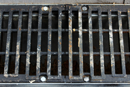a grid for stormwater on the side of a city road. repair and expansion of the road at the exit of the city. Gatchina, Leningrad region, reportage shooting.の写真素材