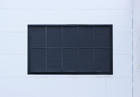 A window in a large industrial shopping center closed with external jalousie in the form of...