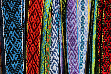 Many colorful belts with patterns. Folk art, handmade. Fair of folk art during the festival in the Republic of Crimea.の写真素材