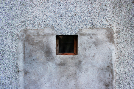 a small square window with a wooden frame leading to the basement, covered with fine grating and glassの写真素材