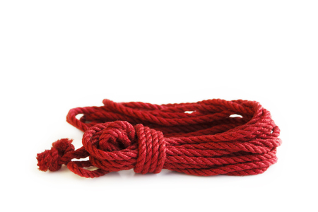 One skein of jute rope six millimeters for Japanese bondage and shibari, painted in red on a white background. Professionally knitted hankの写真素材