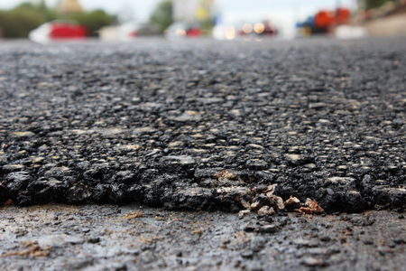 texture of fresh hot black asphalt is laid on the new automotive road edge of rolling.の写真素材