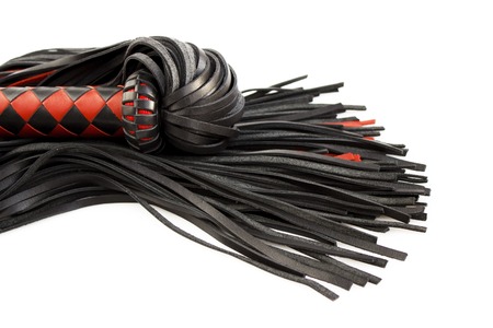 Red-black floger with a patterned handle and leather tails on white background.concept of pleasure from pain.の写真素材