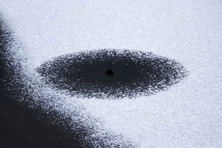 round small hole in thin ice on a lake in the Gatchina parkの写真素材