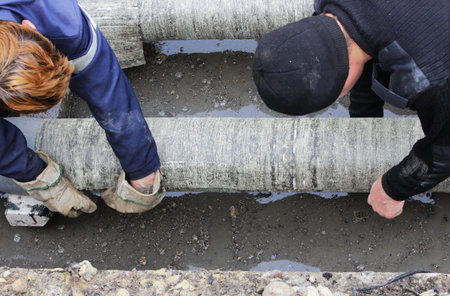emergency water service team cuts wraps the pipe with pieces of roofing felt and fixes them with...