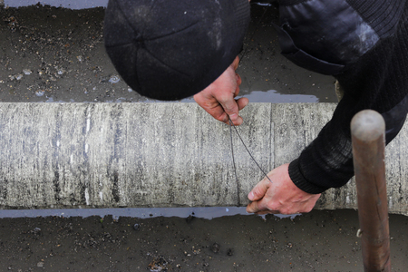 emergency water service team cuts wraps the pipe with pieces of roofing felt and fixes them with stainless steel wire for waterproofing and heat insulation. reportage photography, Russiaの写真素材
