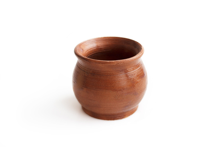 Clay pot, made by hand on a potter's wheel from red clay. Double burning. Transparent glaze applied by hand - visible potter's fingerprints and brush strokes. Handmade, single copy. White background, isolated.の写真素材