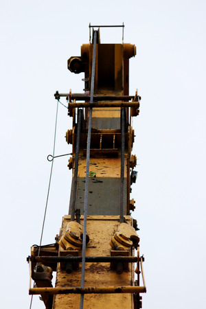 part of old working yellow crane truck for construction on a blue skyの写真素材
