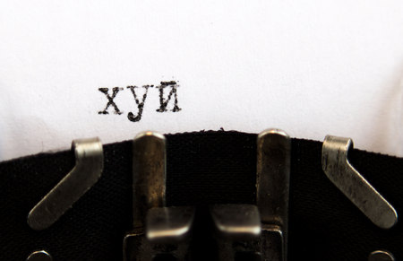 Old soviet typewriter close up. Filled in it blank sheet of paper with the word dick written in Russian. Macro.の写真素材