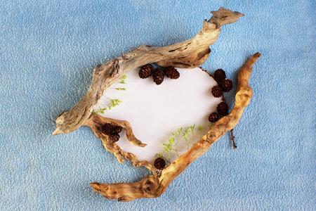 original frame in the form of a heart made of paper, small wooden blocks and cones on a blue terry clothの写真素材