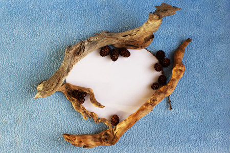 original frame in the form of a heart made of paper, small wooden blocks and cones on a blue terry clothの写真素材