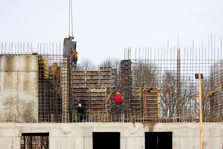 the worker and the crane operator unload the car with reinforced concrete walls for building a large wellness center with a swimming pool of modern technology with concrete poured reinforced and formwork walls. reportage.の写真素材