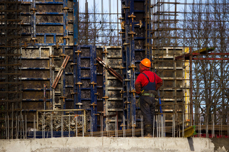 the worker and the crane operator unload the car with reinforced concrete walls for building a large wellness center with a swimming pool of modern technology with concrete poured reinforced and formwork walls. reportage.の写真素材