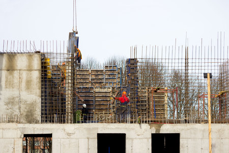 the worker and the crane operator unload the car with reinforced concrete walls for building a large wellness center with a swimming pool of modern technology with concrete poured reinforced and formwork walls. reportage.の写真素材
