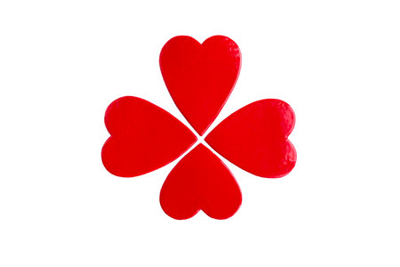 the image of the happy symbol - four-leafed trefoil with the help of ceramic hearts. Symbol of love and good luck, St. Patricks Day. Clay, covered with red glaze, double firing. Isolated on a white backgroundの写真素材