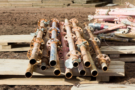 old disassembled scaffolding in the form of tubes, painted in paint lie on the construction site for the restoration of the palaceの写真素材
