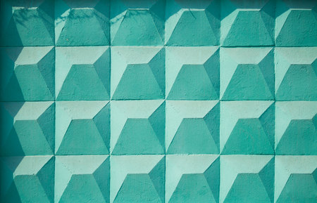 Textured wall of concrete in the form of geometric elements painted in turquoise.の写真素材