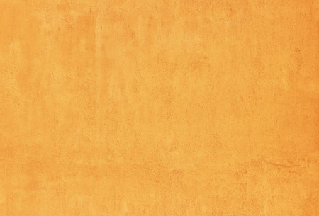 orange brick evenly plastered wall illuminated by the evening sun. industrial textured background.の写真素材