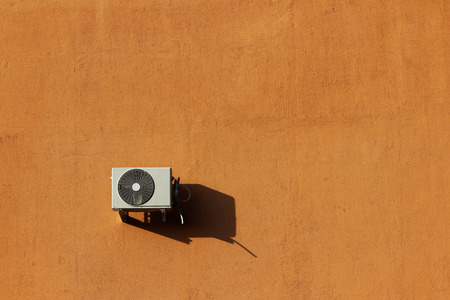 one outer industrial air conditioners are cooling the air in a large shopping center in the summer. orange brick plastered wall background.の写真素材