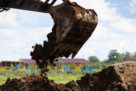 the dirty work of the excavator bucket, which digs ground on the wasteland near the house to detect crash water pipes. reportage.の写真素材