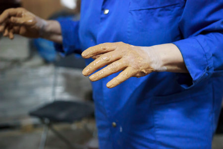 An elderly woman came to study pottery and ceramics. Hands in red clay. training, reportage.の写真素材