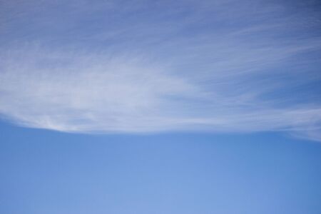 Blue sky with a large white translucent cloud. blue and white in halfの写真素材