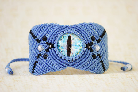 blue bracelete with white beads and the dragons eye on the hand from waxed thread in the technique...