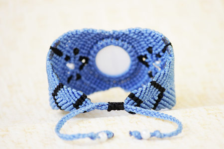blue bracelete with white beads and the dragons eye on the hand from waxed thread in the technique...