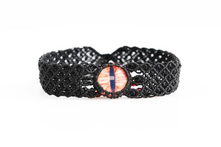 black choker with red dragon's eye for neck from waxed thread in the technique of macrame on a white background. Handmade. Concept bdsm.の写真素材