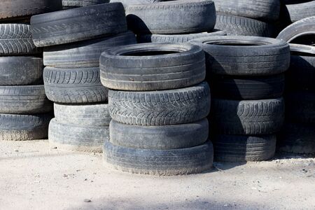 old car tires stacked near the forest. concept of ecological disaster and illegal dumps.の写真素材