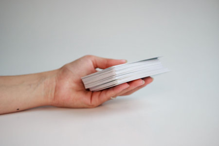fortune-tellers' hands hold a deck of tarot cards on a gold background.の写真素材
