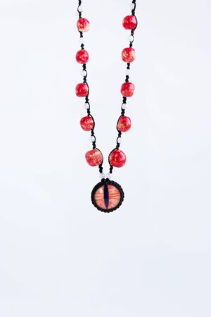 dragon red eye cabochon and ceramic beads on a white background. Amuletの写真素材