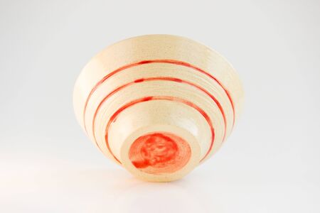 small beige plate with red stripes. handmade. made on a potter s wheel, covered with transparent glaze, burned in a kiln. bottom viewの写真素材