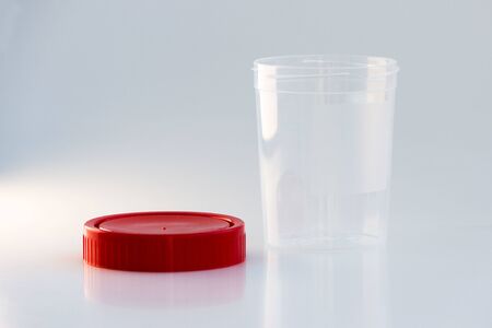 transparent plastic jar with a red lid on a white background. for analysis.の写真素材