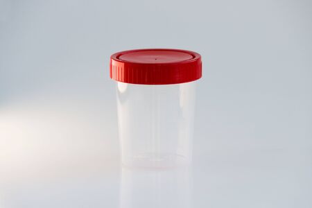 transparent plastic jar with a red lid on a white background. for analysis.の写真素材