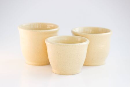 Three beige tea bowls. handwork. cups of different sizes are made on a pottery wheel. covered with clear glaze and burned.の写真素材