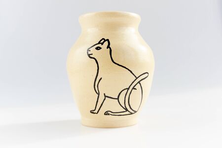 small vase with an Egyptian cat made of beige clay covered with transparent glaze. Ancient Egyptian hieroglyphの写真素材