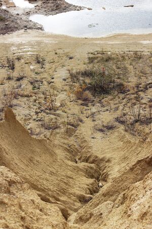 sand quarry. The crack between the two sand dunes is washed out by the rainの写真素材
