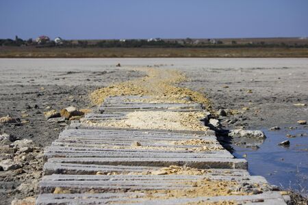 dried salty lake and wooden walkways going from the shore.の写真素材