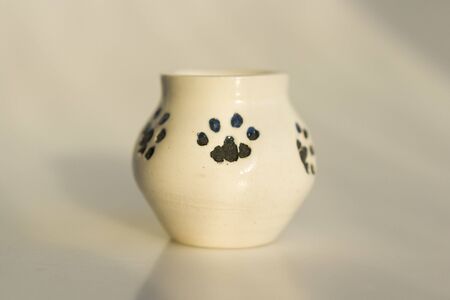 small white potty with cat's legs. prints of cat's paws. ceramic product. author's work.の写真素材