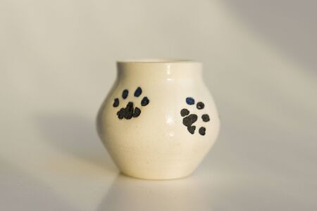 small white potty with cat's legs. prints of cat's paws. ceramic product. author's work.の写真素材