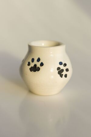 small white potty with cat's legs. prints of cat's paws. ceramic product. author's work.の写真素材